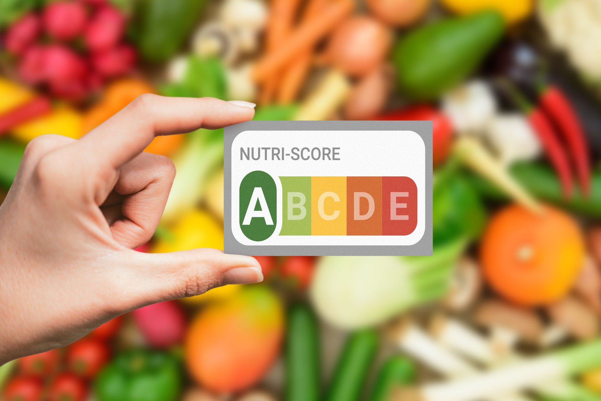 Tarjeta Nutri-Score de mano con fondo de alimentos saludables